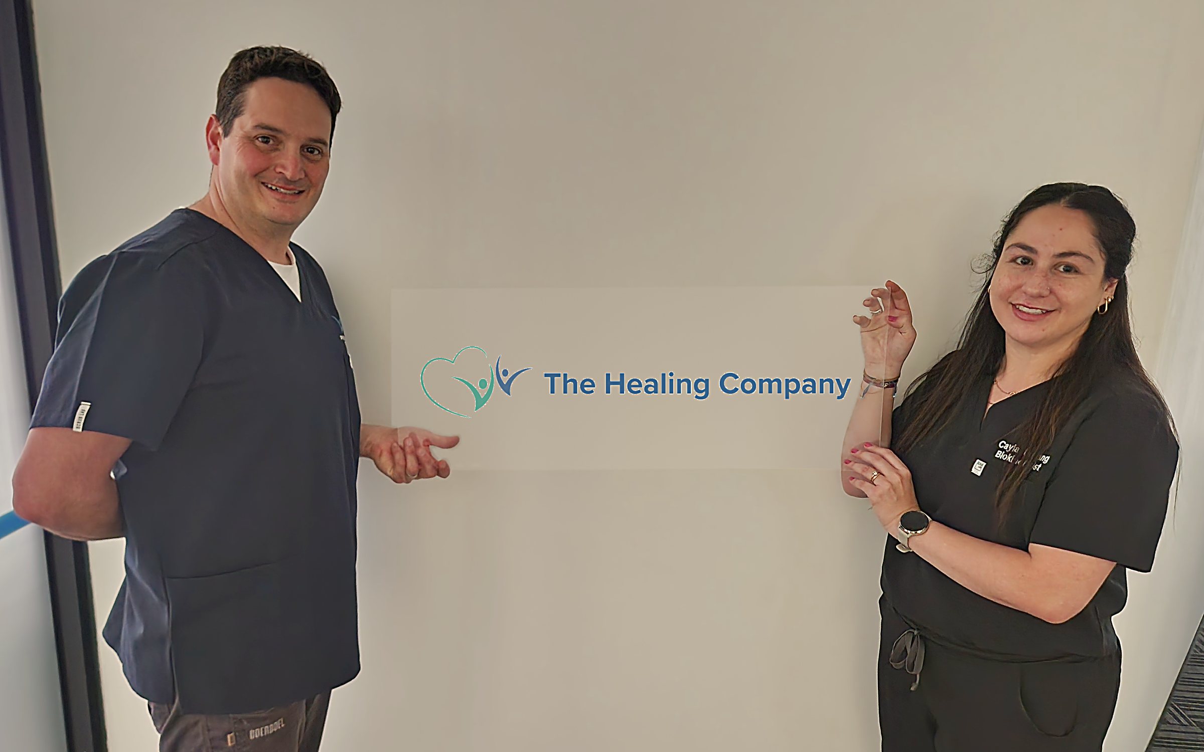 Dr Steven Smilkstein and Cayla Urdang holding The Healing Company sign